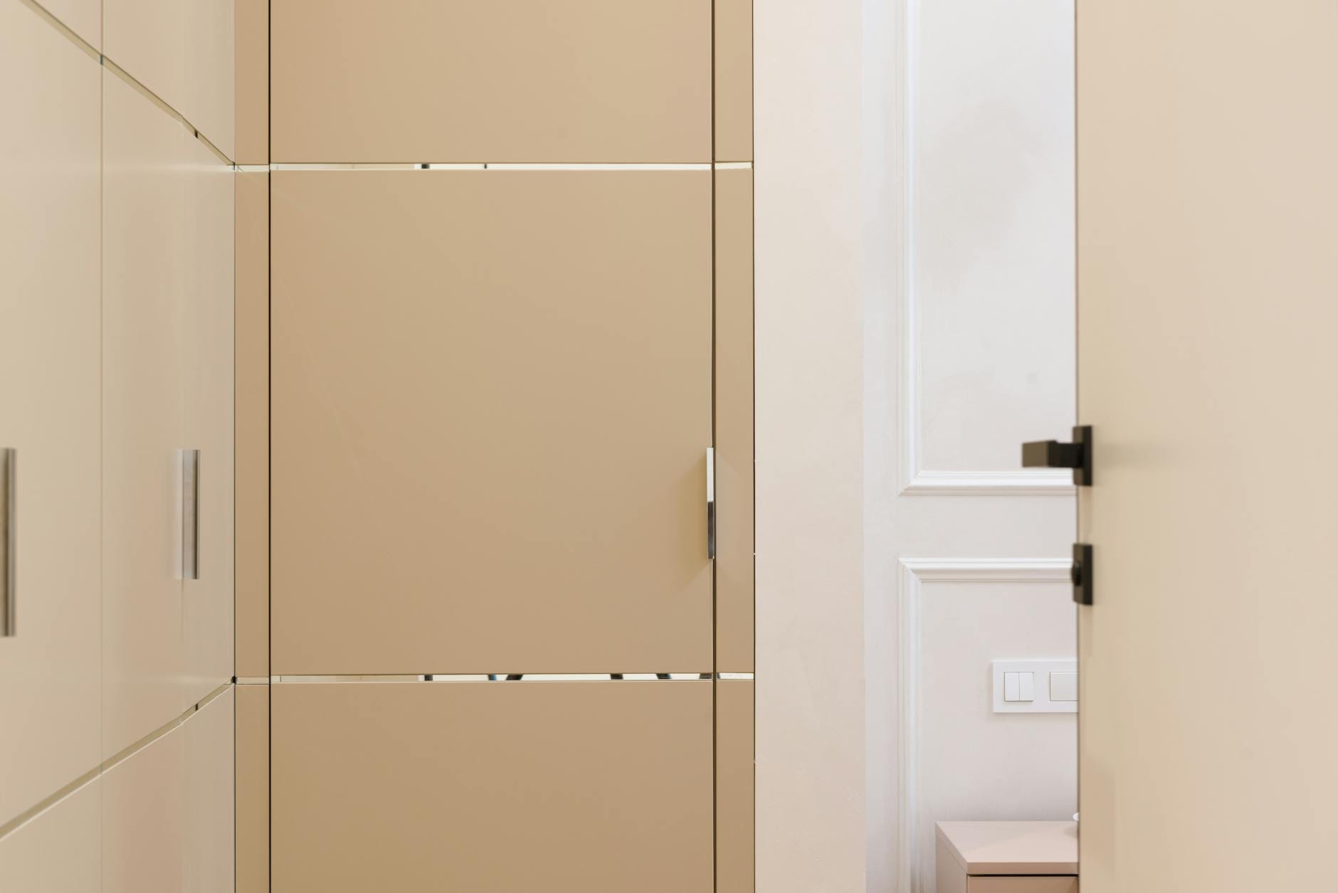 Beżowa zabudowana garderoba w minimalistycznym przedpokoju