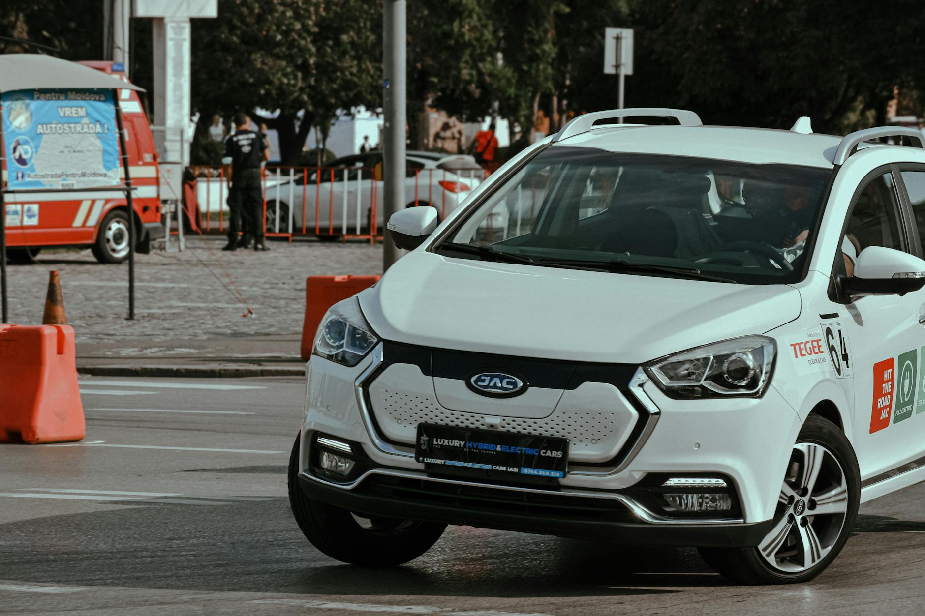 Jak obniżyć koszty eksploatacji samochodu elektrycznego w mieście i na trasie Białe nowoczesne auto przyspiesza na zakręcie miejskiego toru