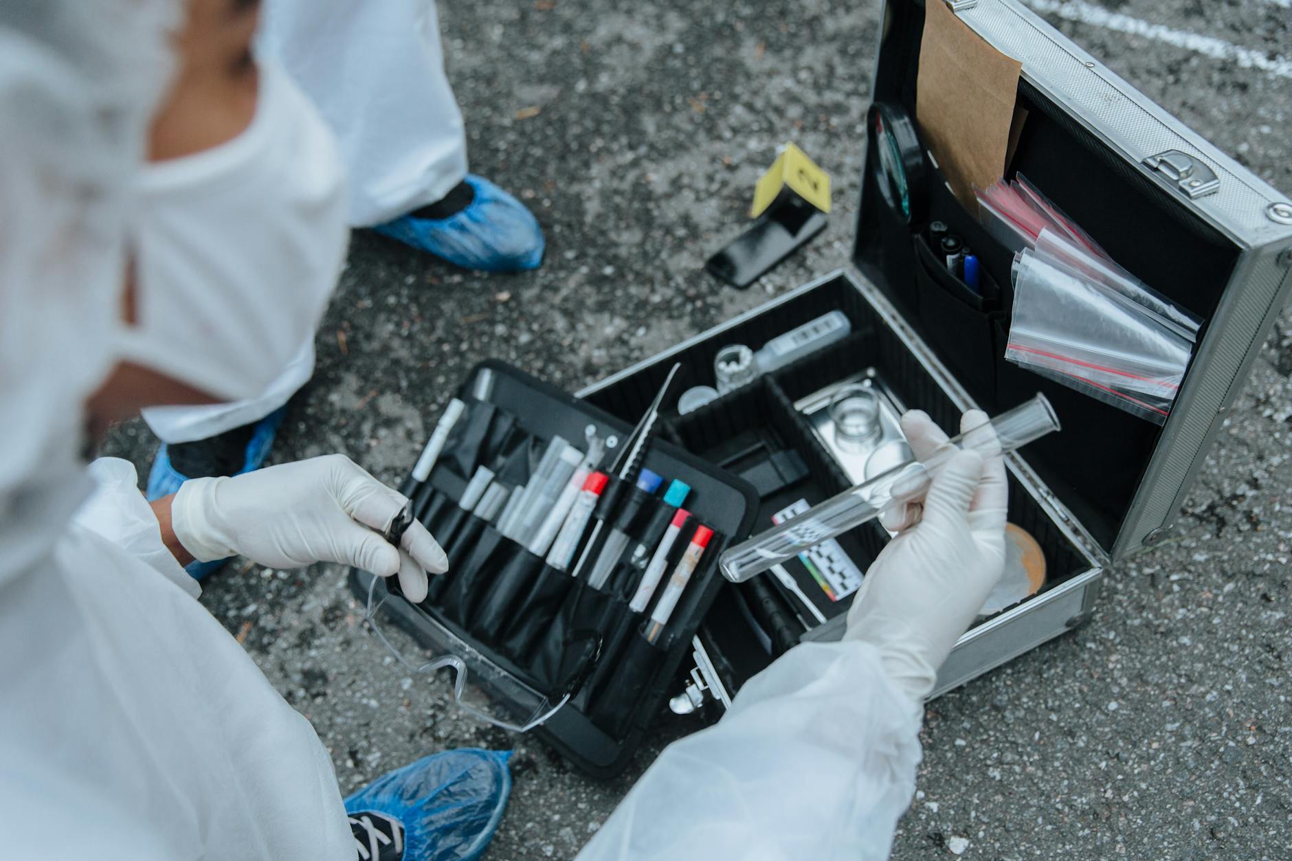 Analiza miejsca zbrodni krok po kroku: jak pracują współcześni technicy kryminalistyczni Technik kryminalistyki bada ślady na miejscu zbrodni na świeżym powietrzu