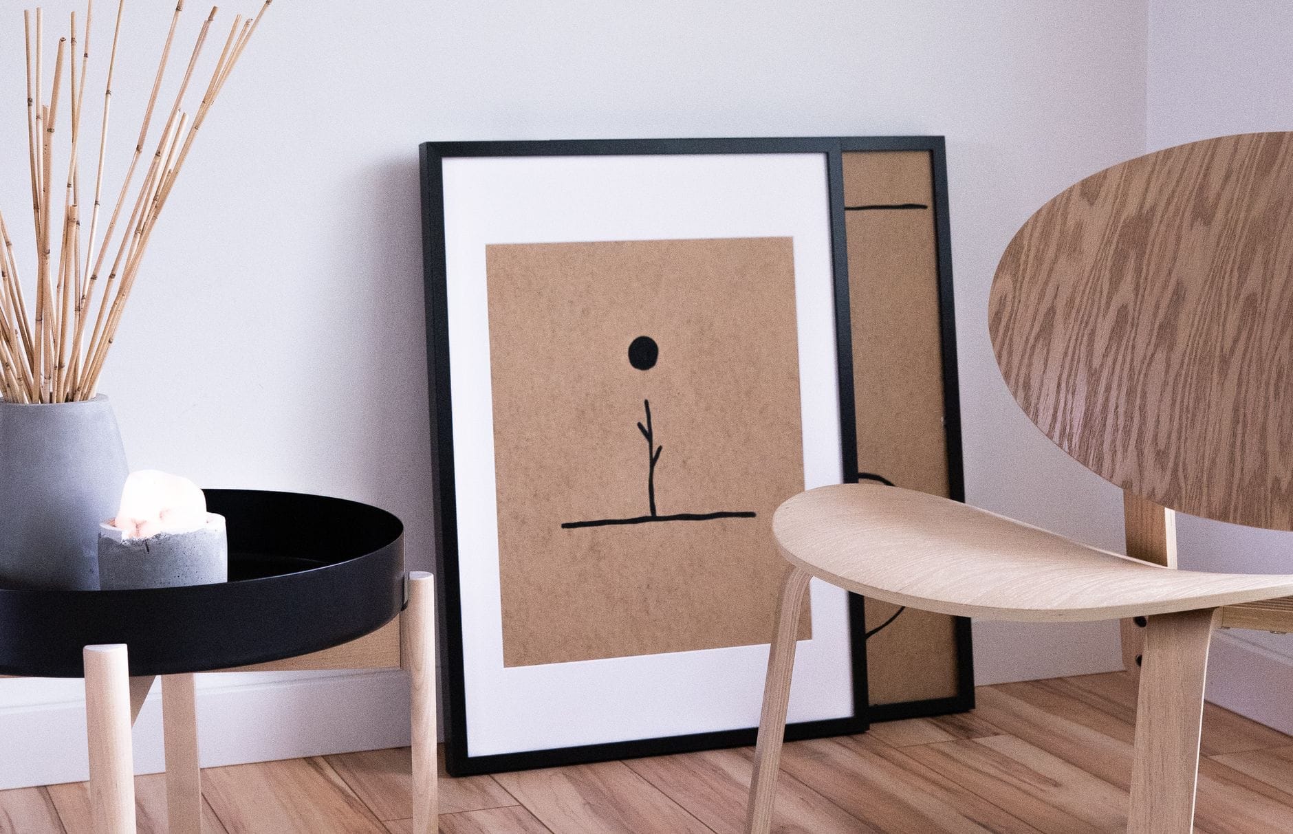Jasny salon japandi z minimalistycznymi drewnianymi meblami i abstrakcyjnym obra