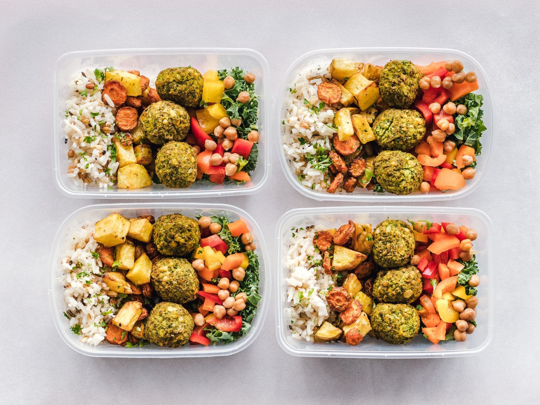 Jak wybrać catering dietetyczny dla zapracowanych: porównanie najpopularniejszych diet pudełkowych Kolorowe pudełka z falafelem, ciecierzycą, ryżem i warzywami na diecie pudełkowe