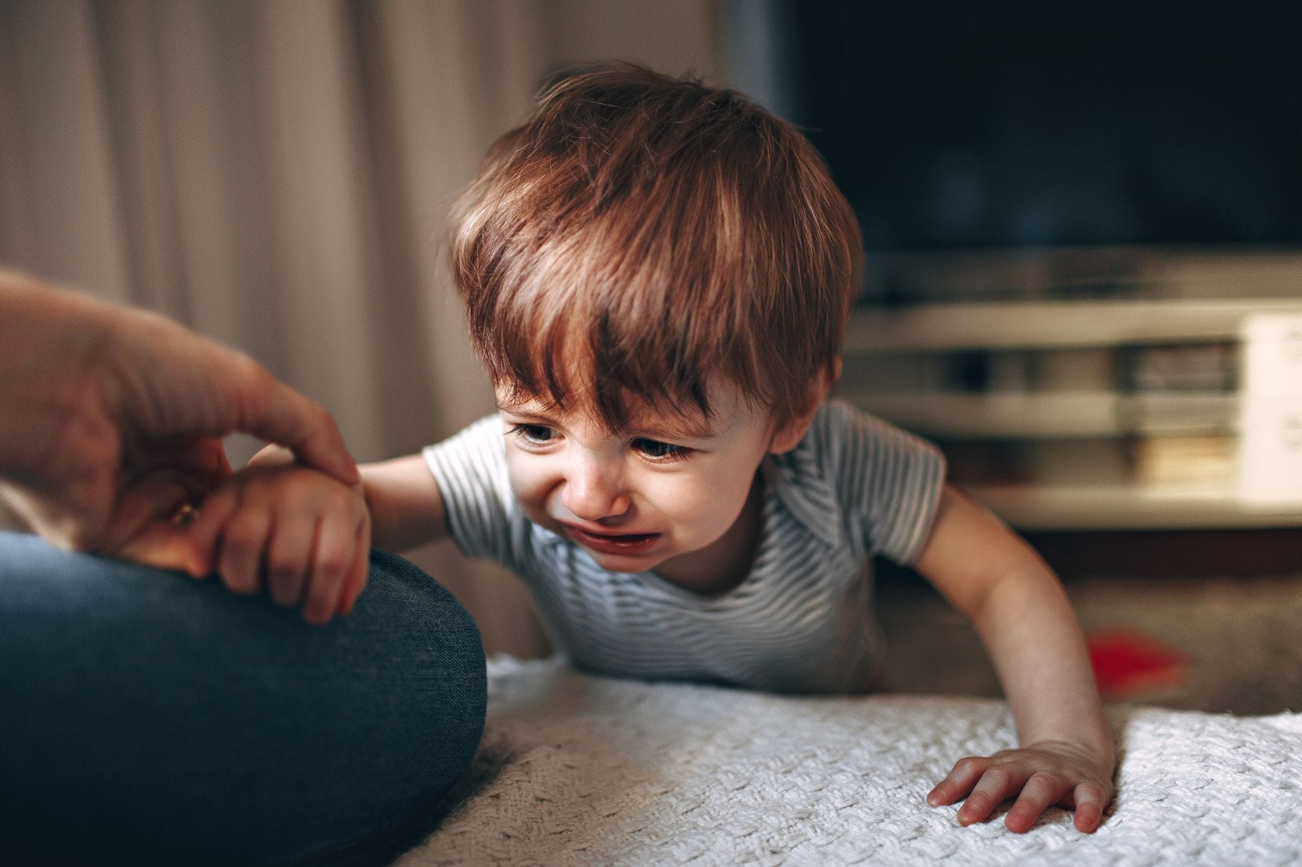 Jak rozpoznać u dziecka pierwsze objawy depresji i kiedy zgłosić się do poradni psychologiczno-pedagogicznej Zasmucone dziecko siada na kanapie obok wspierającego rodzica